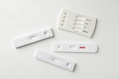 Photo of Different disposable express tests on white table, flat lay