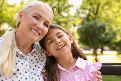 Mature woman with her little granddaughter resting together in park