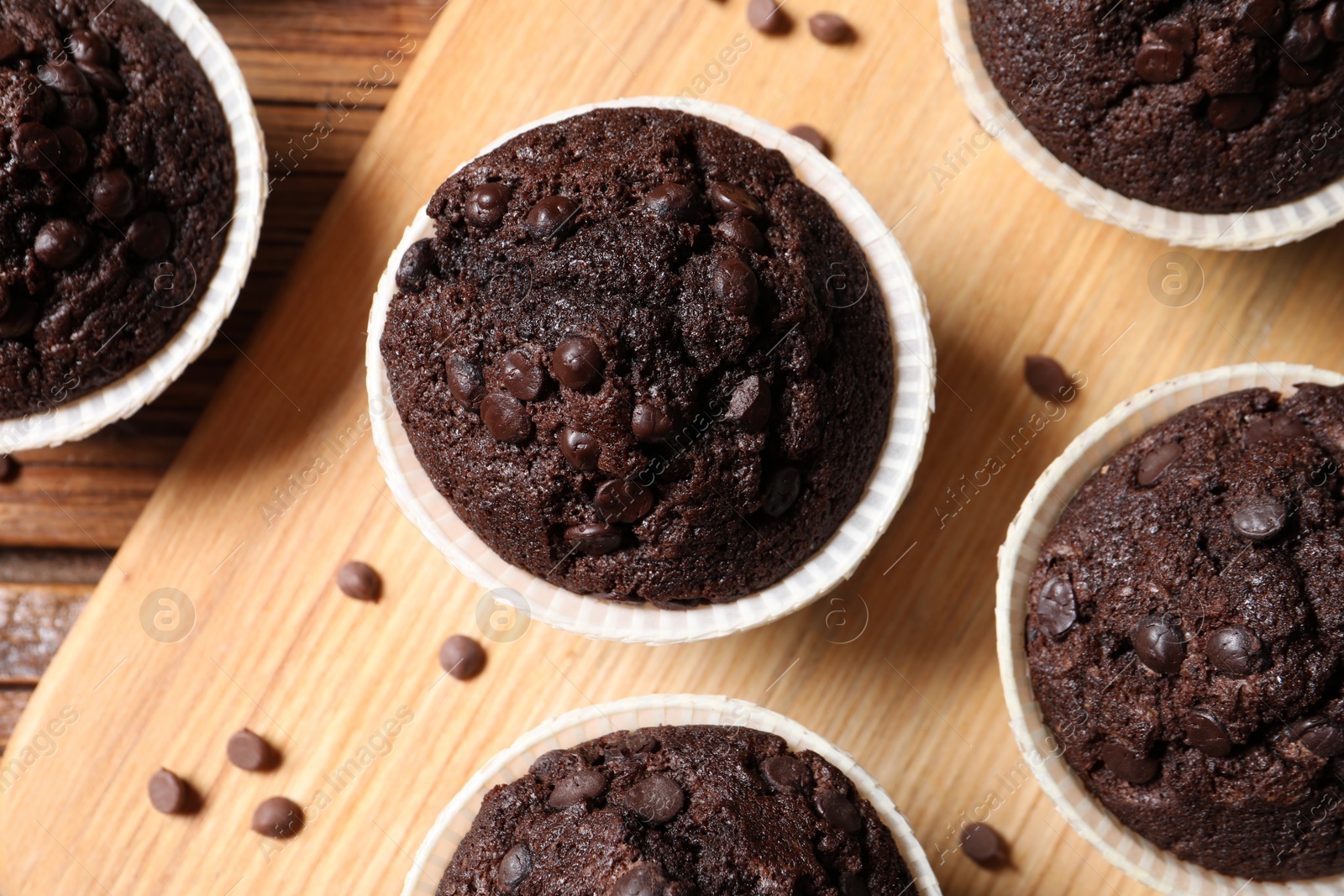 Photo of Tasty chocolate muffins on wooden table, flat lay