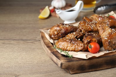 Photo of Tasty chicken glazed in soy sauce served on wooden table, closeup. Space for text