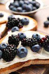 Photo of Tasty sandwiches with cream cheese and berries, closeup