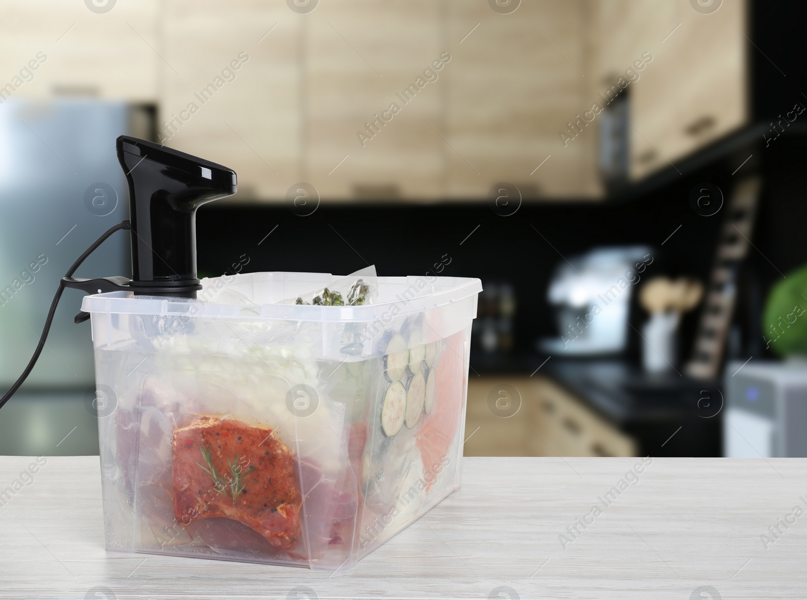 Image of Sous vide cooker and vacuum packed food products in box on wooden table in kitchen, space for text. Thermal immersion circulator