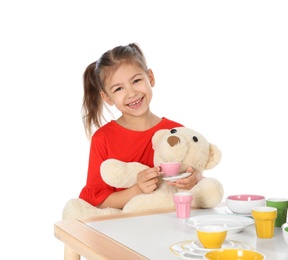 Photo of Little child playing tea party with toy on white background. Indoor entertainment