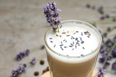 Photo of Delicious coffee with lavender on grey background, closeup