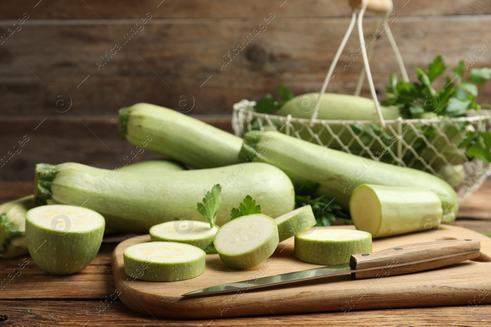 Photo of Cut and whole ripe zucchinis on wooden table