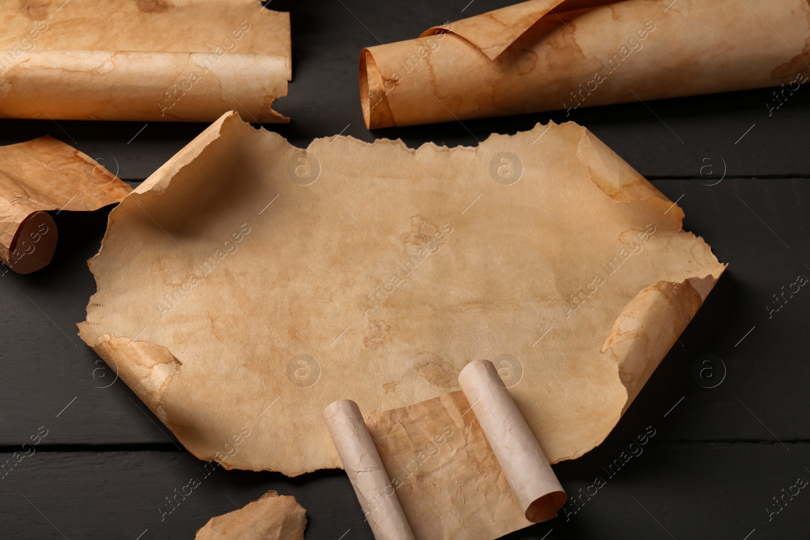 Photo of Sheets of old parchment paper on grey wooden table