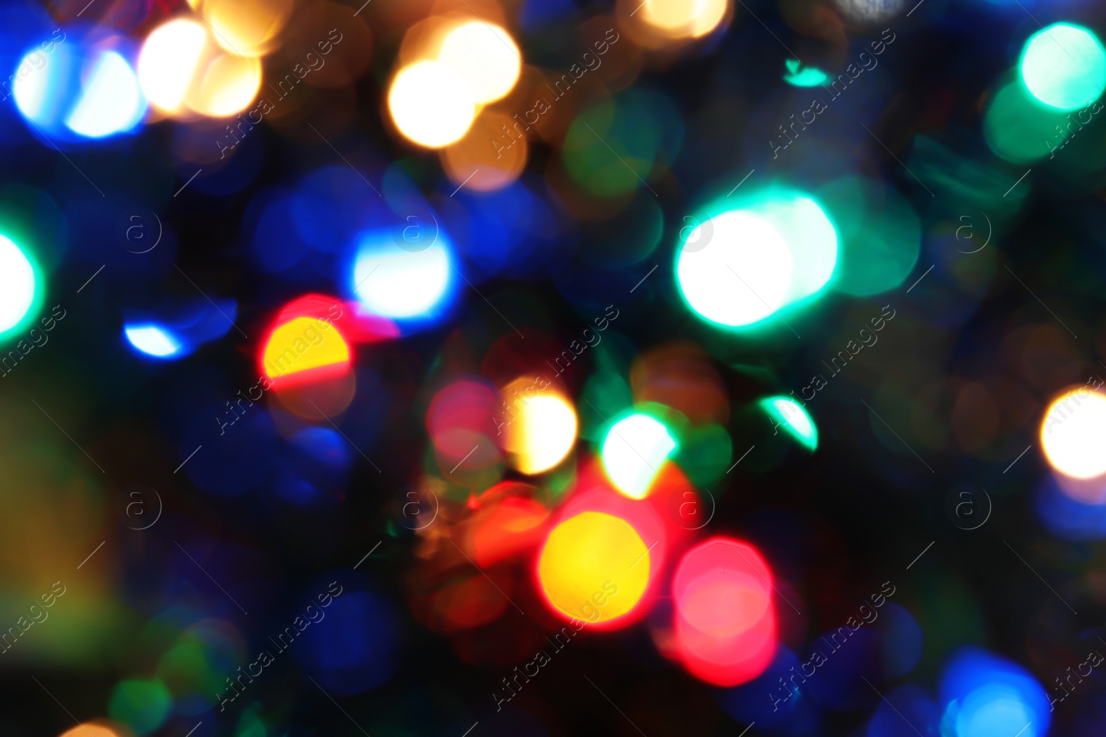 Photo of Blurred view of glowing Christmas lights, closeup