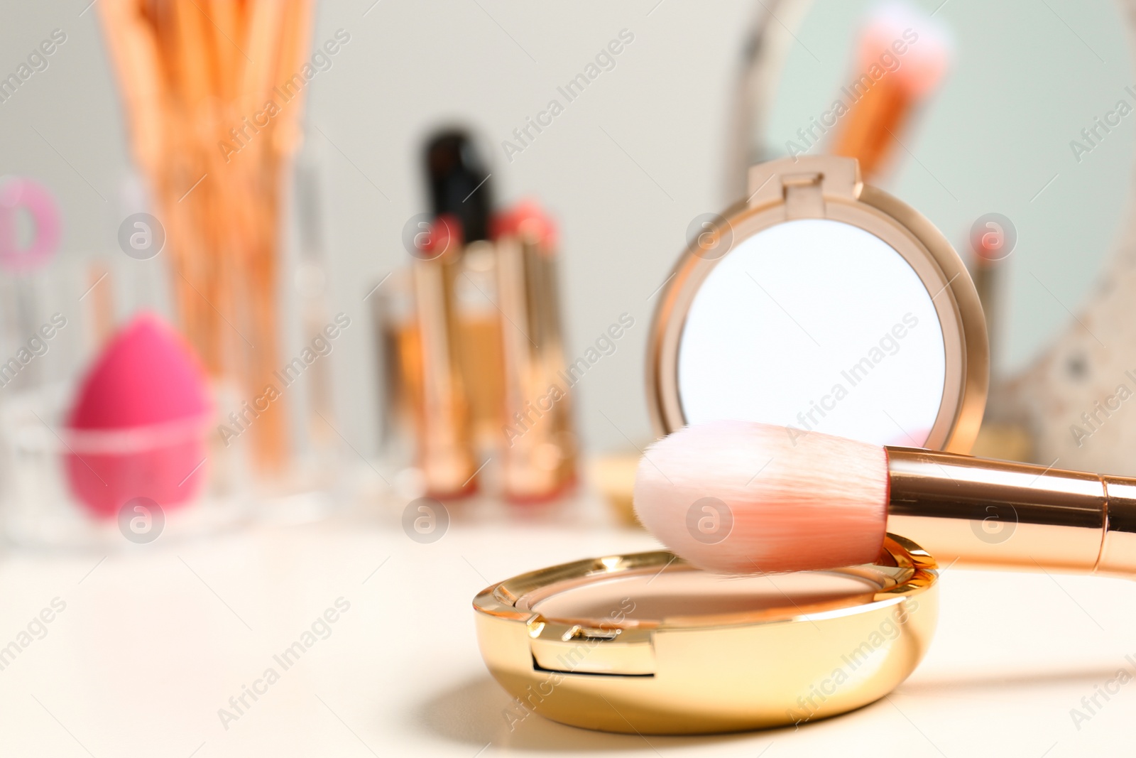 Photo of Compact powder and makeup brush on dressing table. Space for text