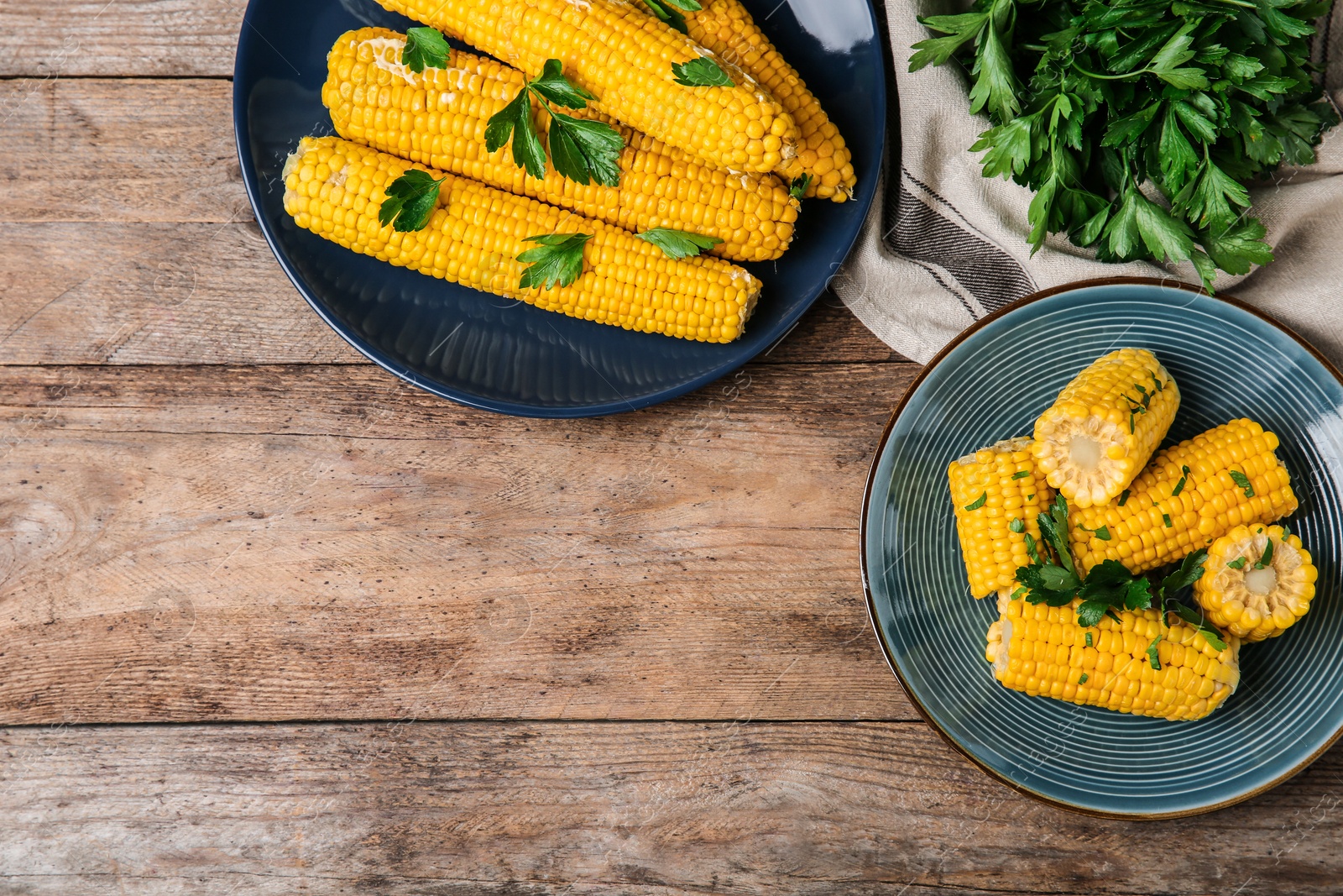 Photo of Flat lay composition of boiled corn cobs on wooden table. Space for text