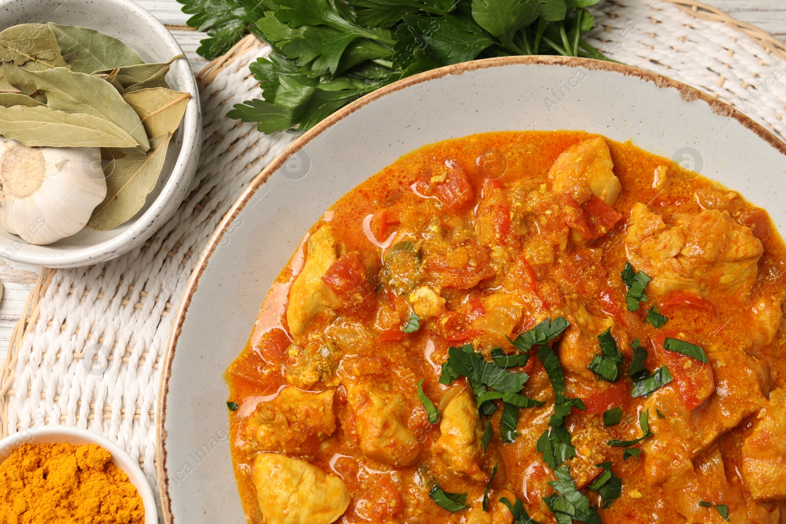 Photo of Delicious chicken curry and ingredients on table, top view