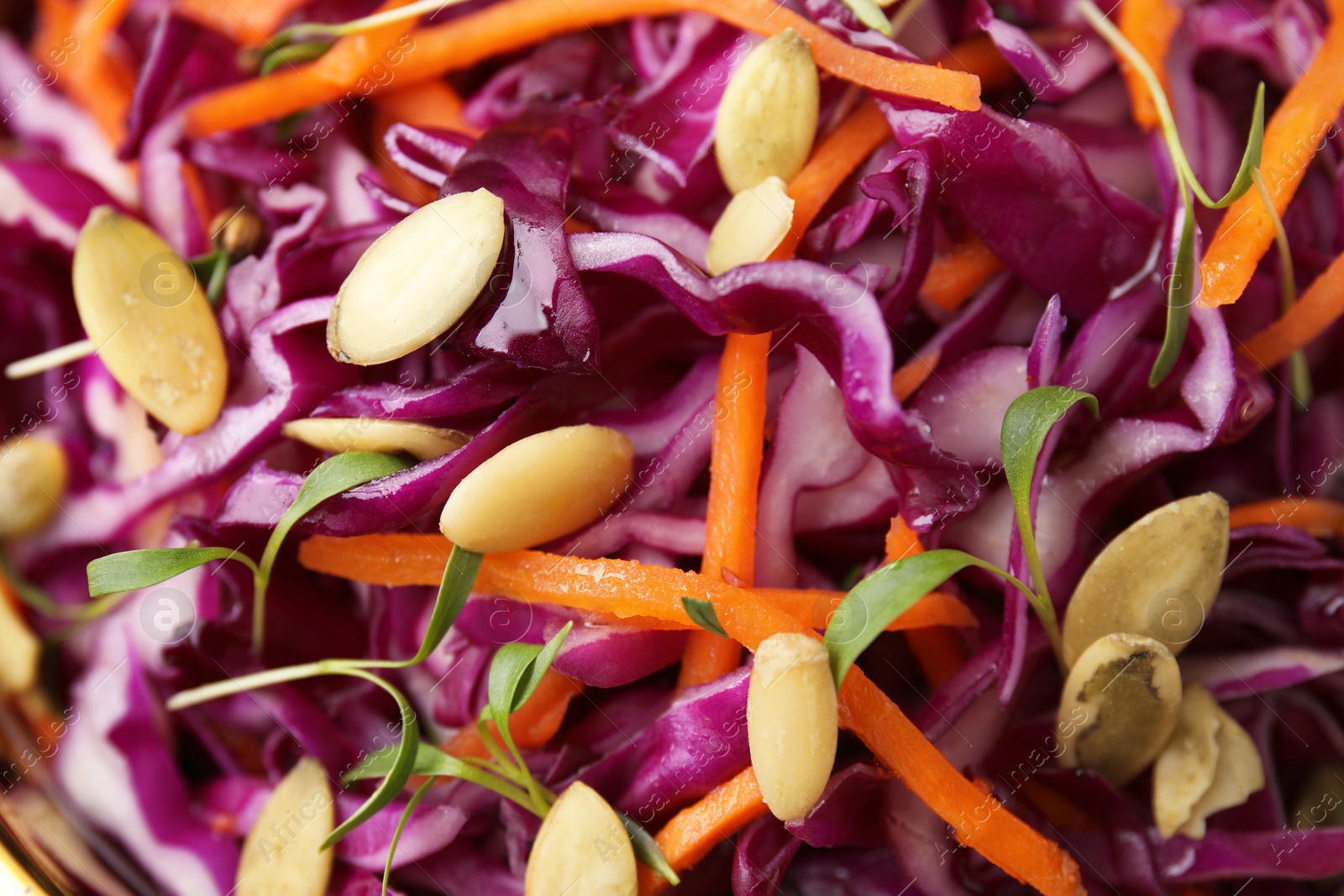 Photo of Tasty salad with red cabbage and pumpkin seeds as background, closeup