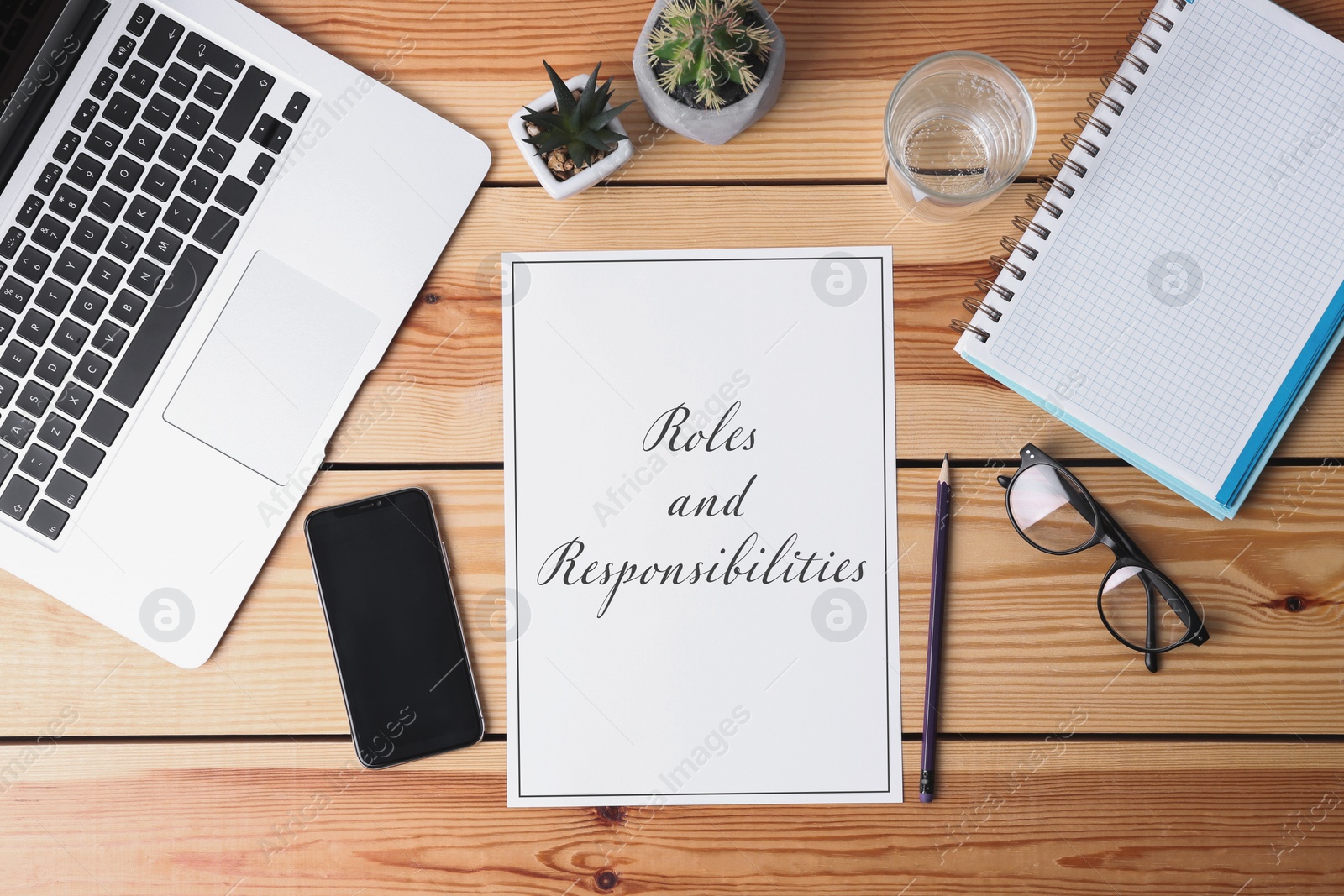 Image of Sheet of paper with text Roles and Responsibilities on wooden background, flat lay