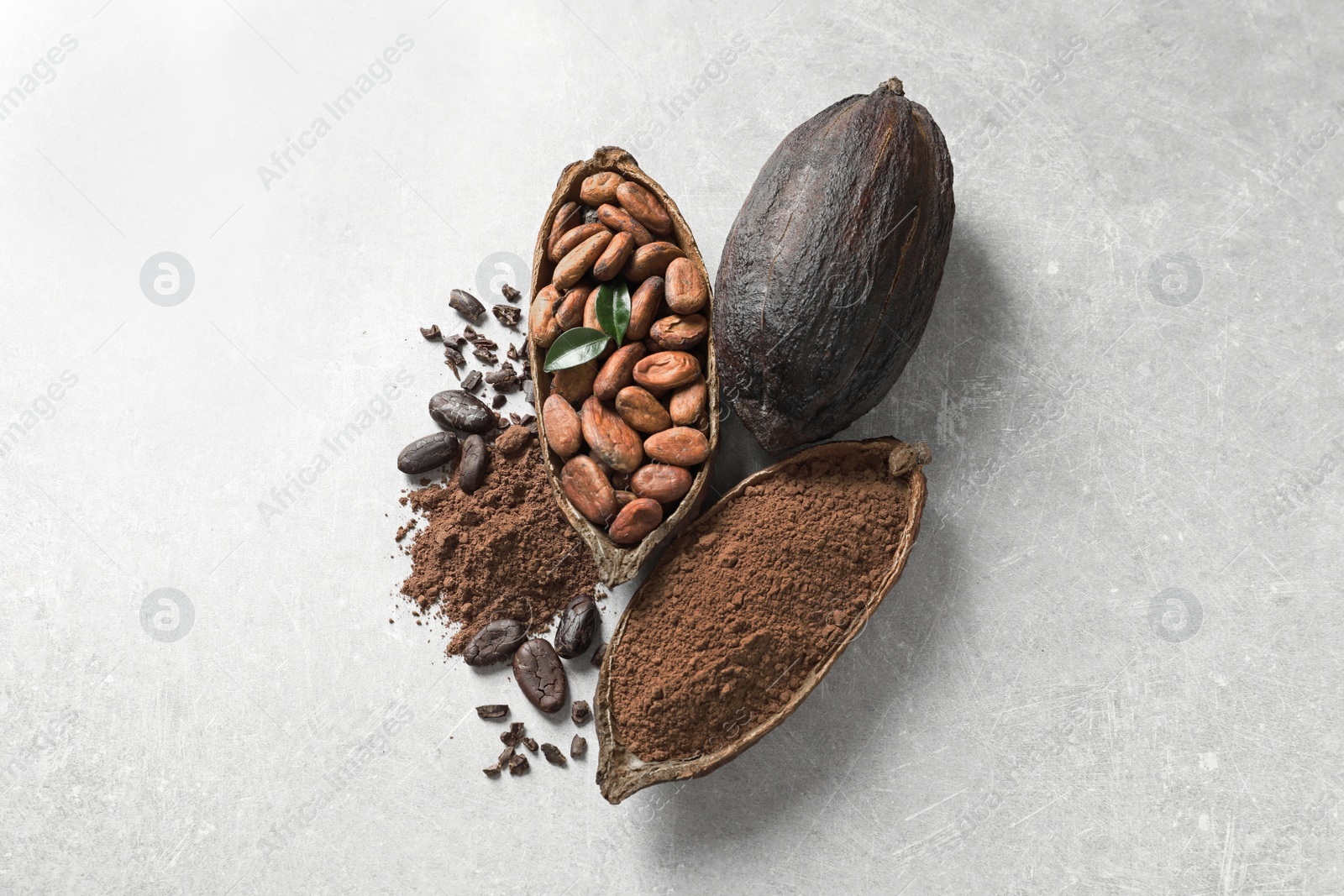 Photo of Cocoa pods, beans and powder on light table, flat lay