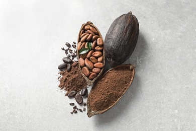 Photo of Cocoa pods, beans and powder on light table, flat lay