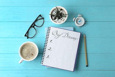 Image of Notebook with dreams list on turquoise wooden table, flat lay 