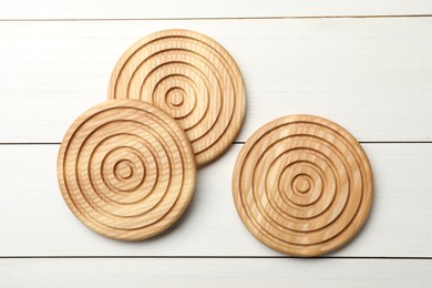 Stylish wooden cup coasters on white table, flat lay