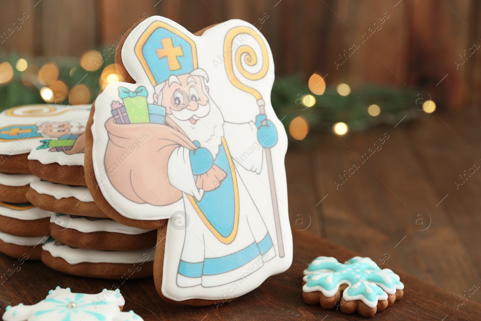 Photo of Tasty gingerbread cookie on wooden table, closeup. St. Nicholas Day celebration
