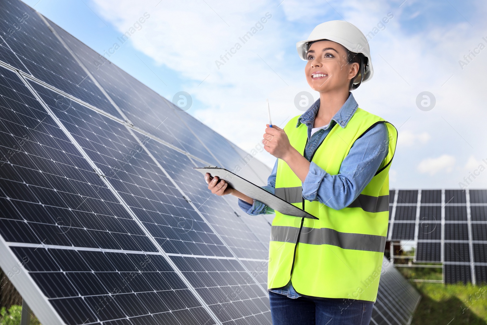 Image of Engineer near solar panels outdoors. Alternative energy source