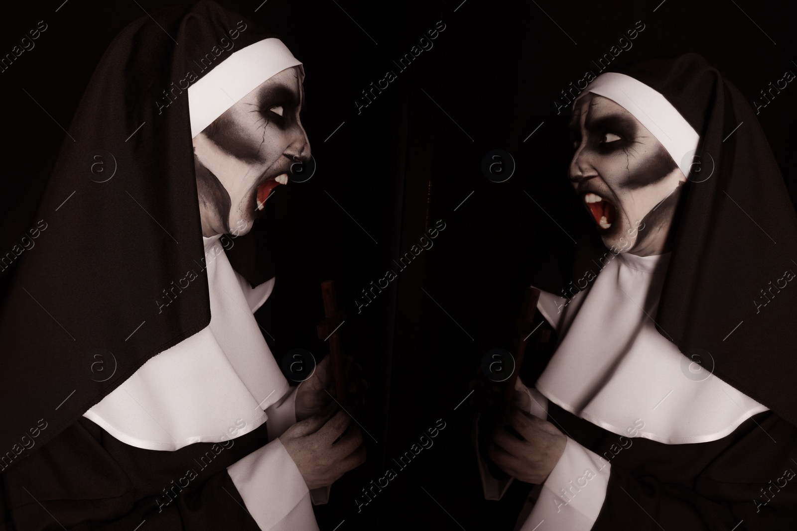 Photo of Scary devilish nun near mirror on black background. Halloween party look