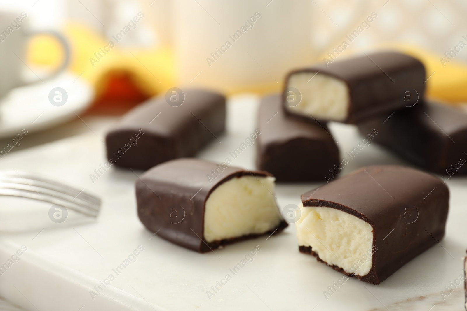 Photo of Glazed curd cheese bars on white board, closeup