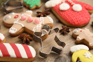 Photo of Christmas biscuits and cookie cutters on wooden background, closeup