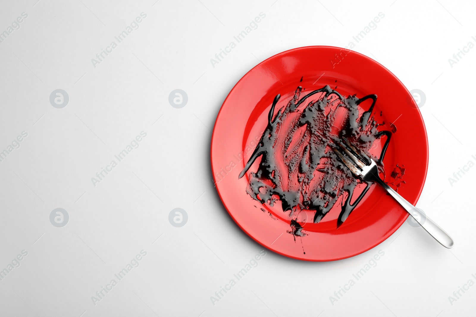 Photo of Dirty plate with food leftovers and fork on white background, top view