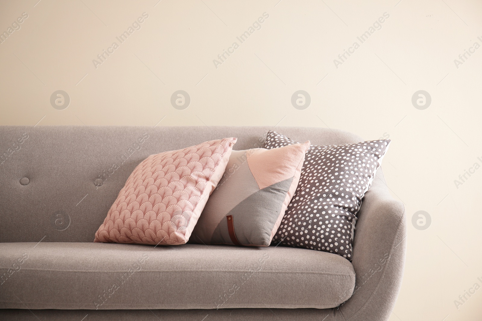 Photo of Different soft pillows on sofa in room