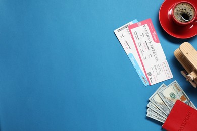Photo of Flat lay composition with passport, tickets and dollars on blue table, space for text. Business trip