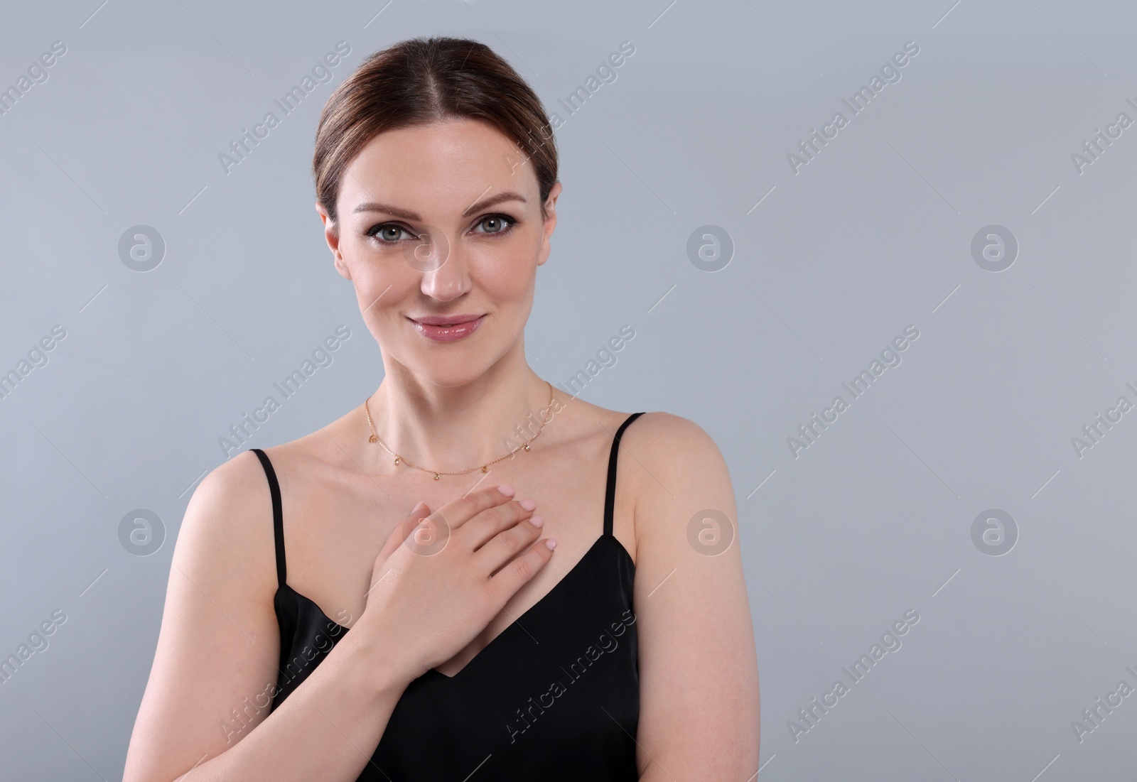 Photo of Beautiful woman with elegant necklace on light grey background. Space for text