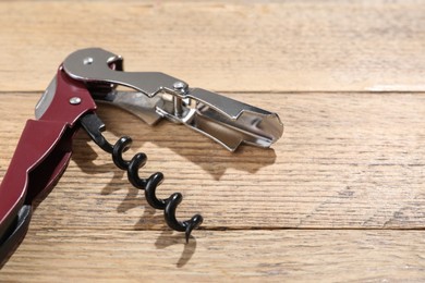 One corkscrew (sommelier knife) on wooden table. Space for text