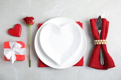 Beautiful table setting for romantic dinner on light grey background, flat lay. Valentine's day celebration