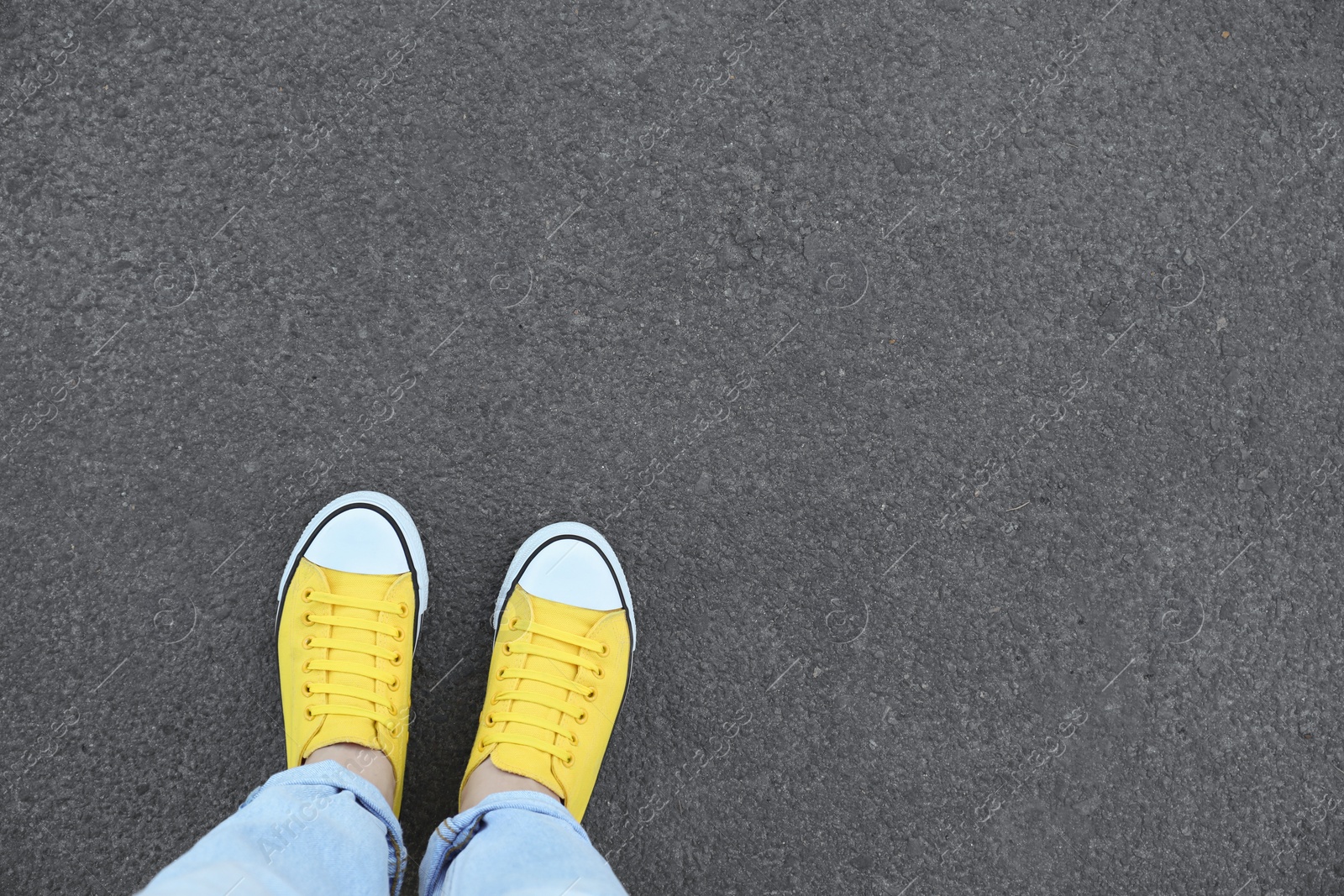 Photo of Woman standing on asphalt, top view. Space for text