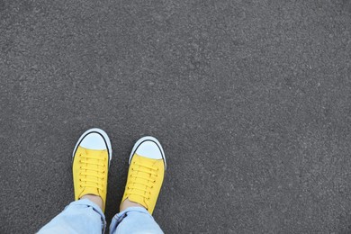 Photo of Woman standing on asphalt, top view. Space for text