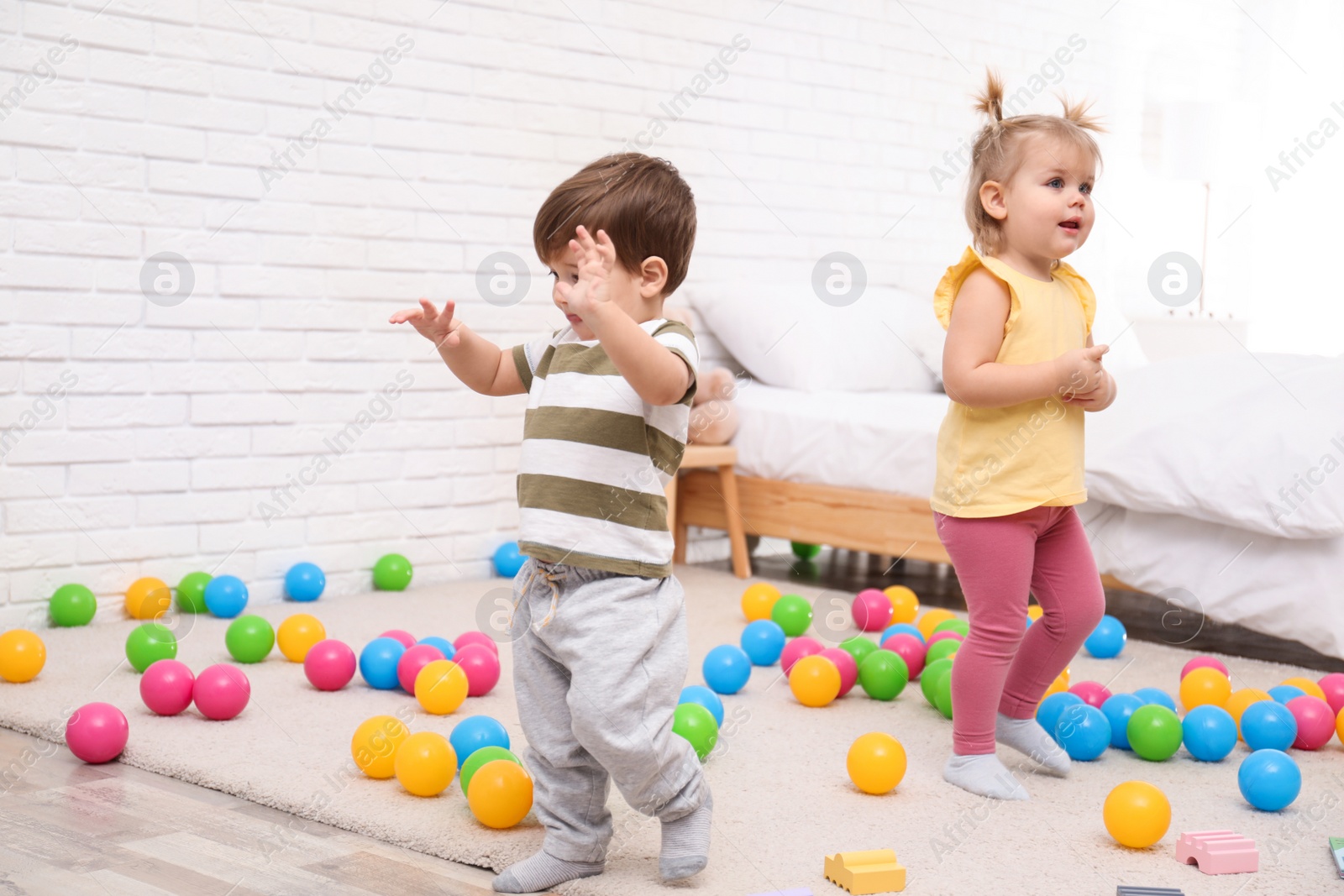 Photo of Cute little children playing together at home