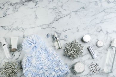 Photo of Flat lay composition with different cosmetic products on white marble table, space for text. Winter care