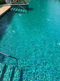 Photo of Metal rail and steps in outdoor swimming pool