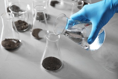 Photo of Scientist preparing soil extract at table, closeup. Laboratory research