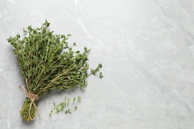 Photo of Bunch of aromatic thyme on light table, top view. Space for text