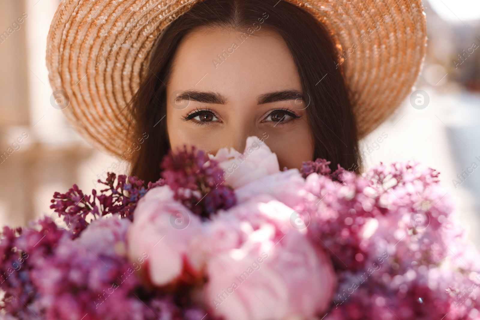 Photo of Beautiful woman with bouquet of spring flowers outdoors, closeup