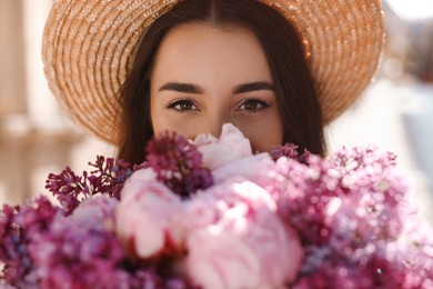 Beautiful woman with bouquet of spring flowers outdoors, closeup