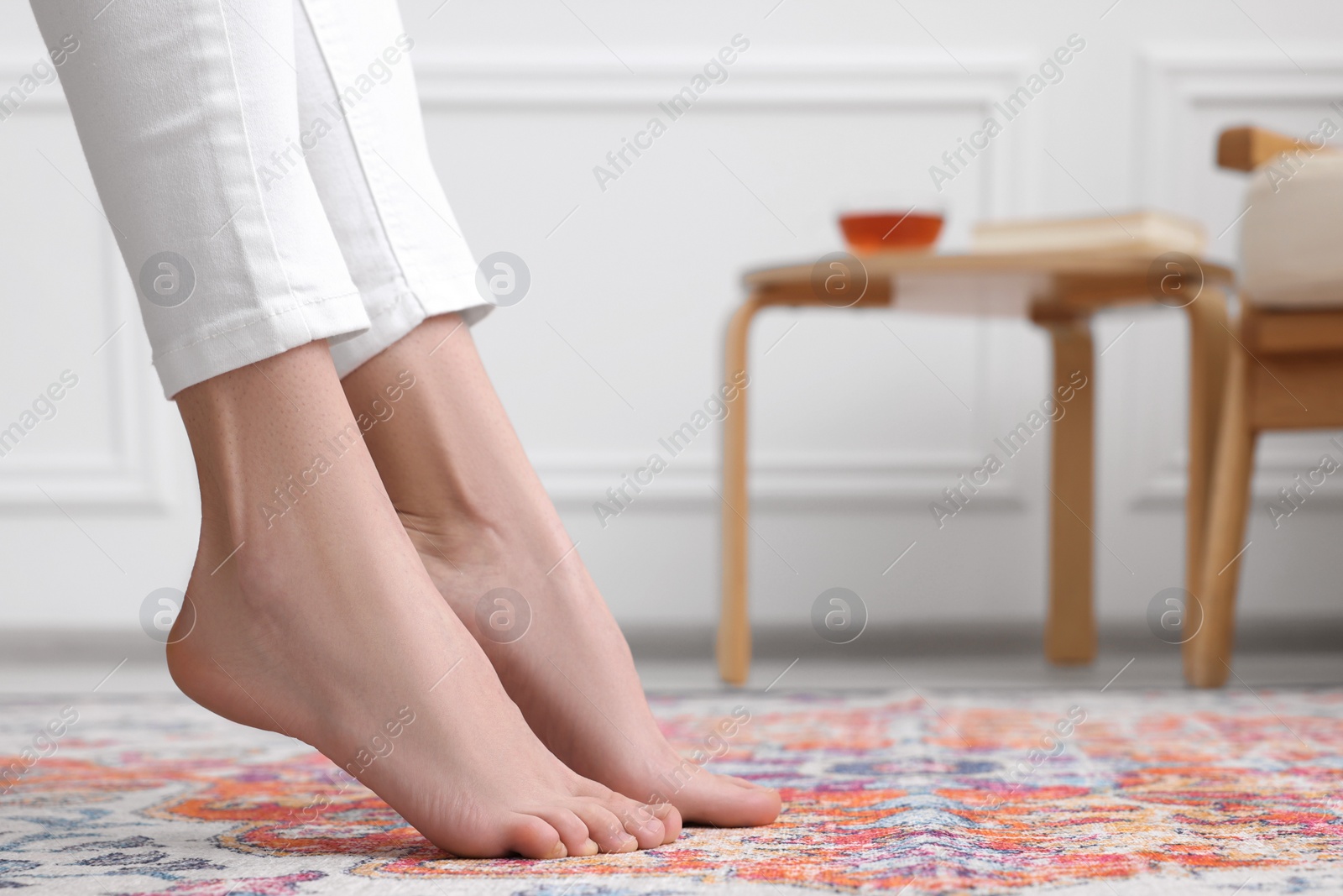 Photo of Woman on carpet with pattern at home, closeup. Space for text