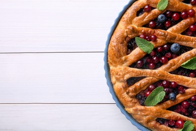 Photo of Delicious currant pie and fresh berries on white wooden table, top view. Space for text