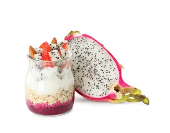 Glass jar of granola with pitahaya, yogurt and strawberries on white background