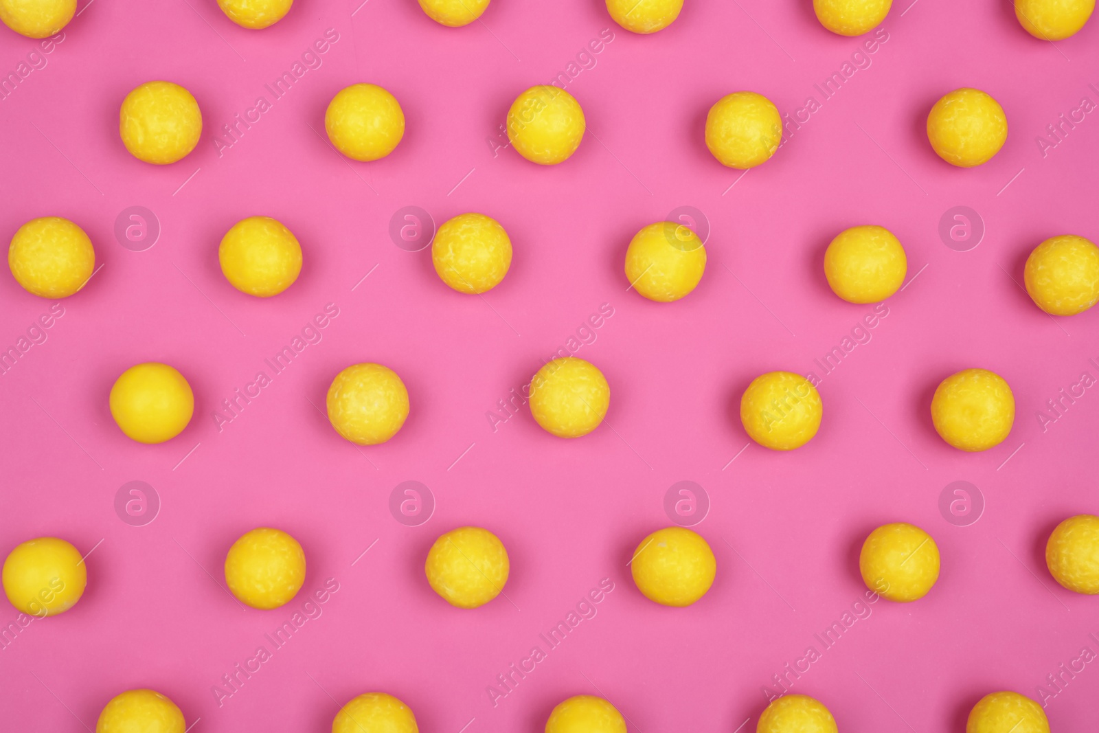 Photo of Many delicious lemon drops on pink background, flat lay