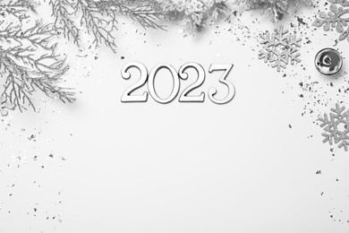 Photo of Flat lay composition with number 2023 and festive decor on white background, space for text. Happy New Year