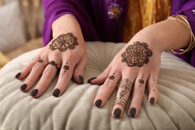 Photo of Woman with henna tattoos on hands, closeup. Traditional mehndi ornament