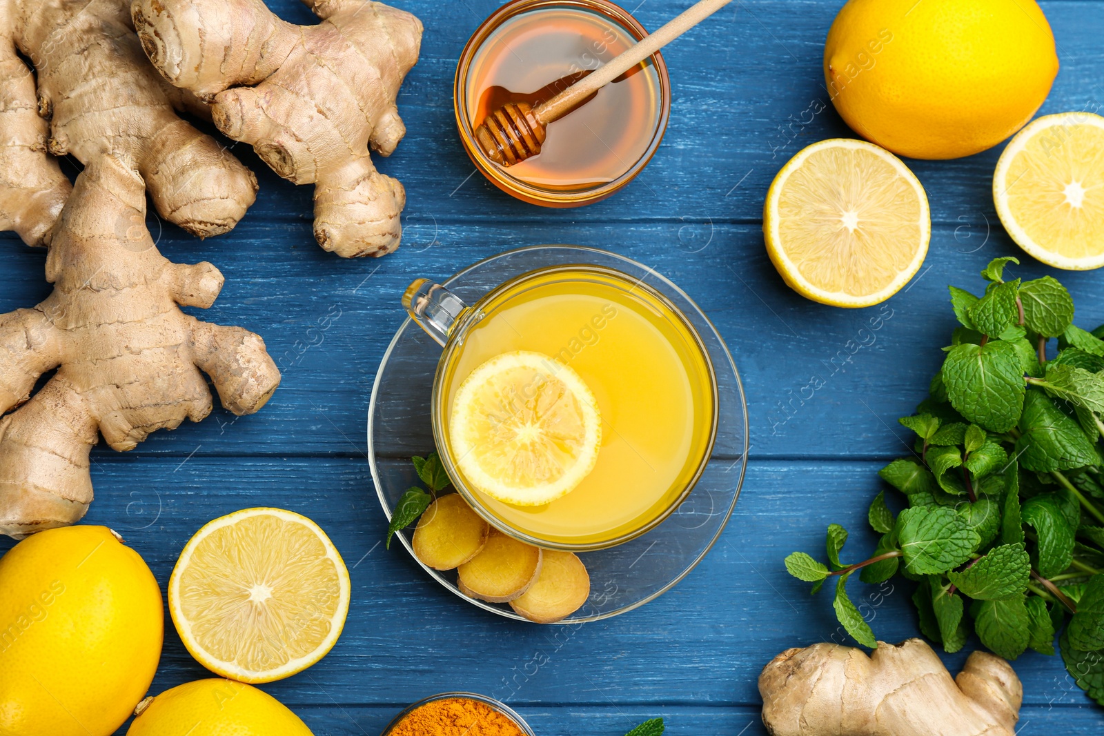 Photo of Flat lay composition with immunity boosting drink and ingredients on blue wooden table