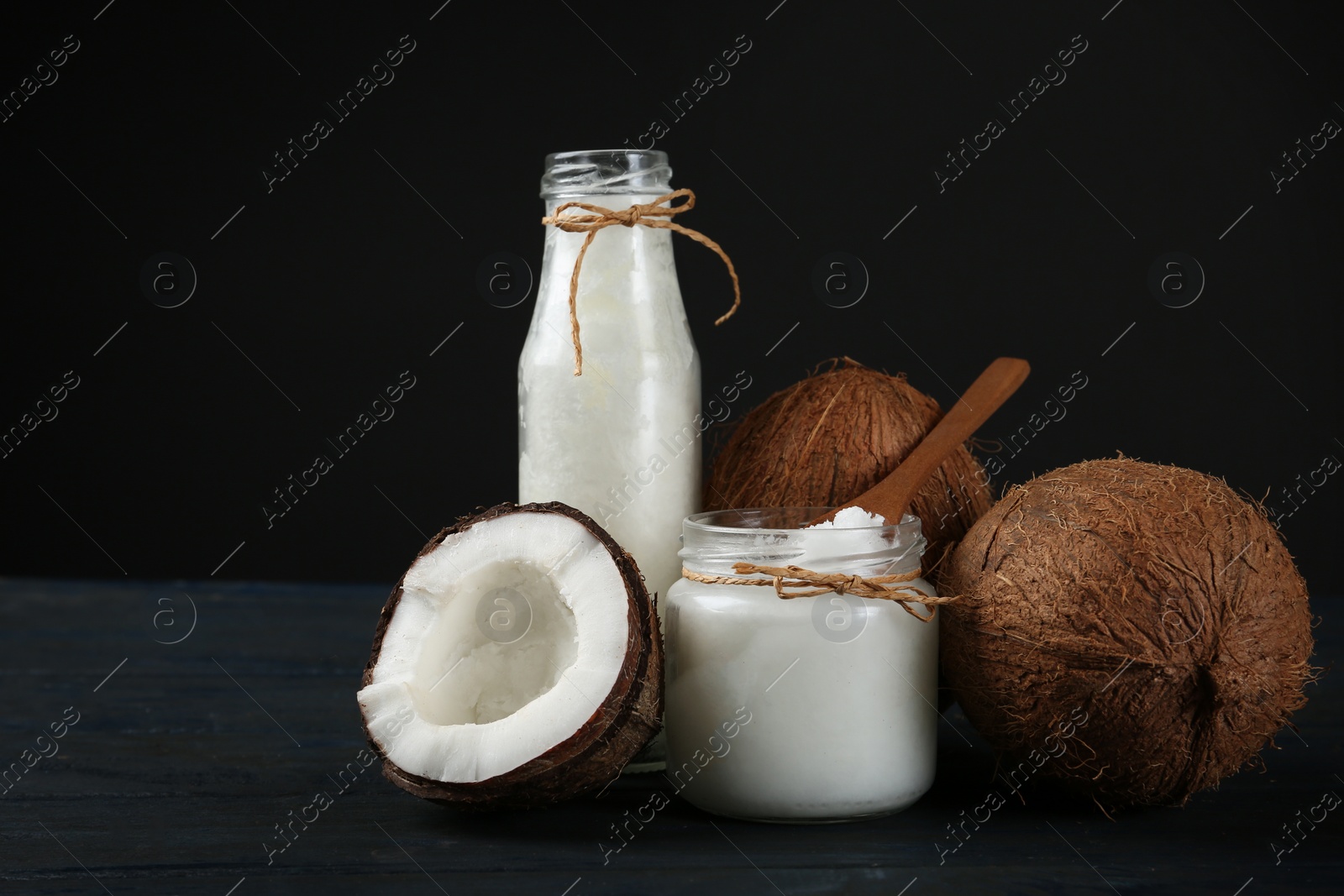 Photo of Fresh coconut oil on dark wooden table. Cooking ingredient