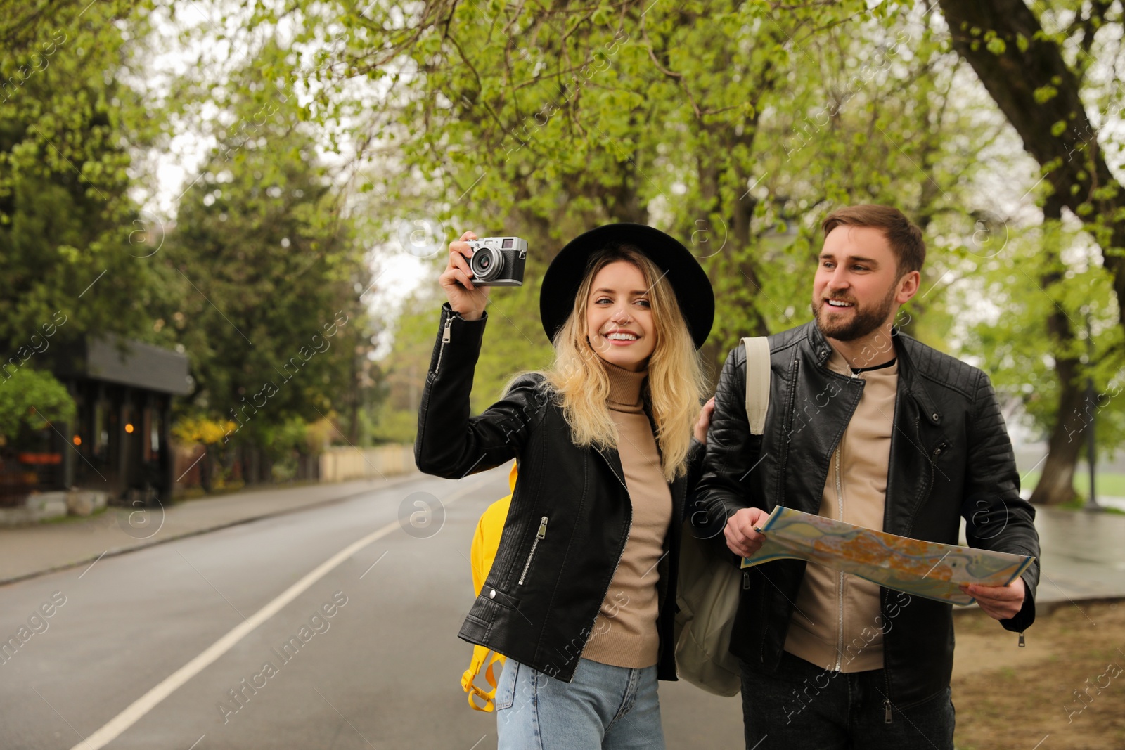 Photo of Couple of tourists with map and camera on city street