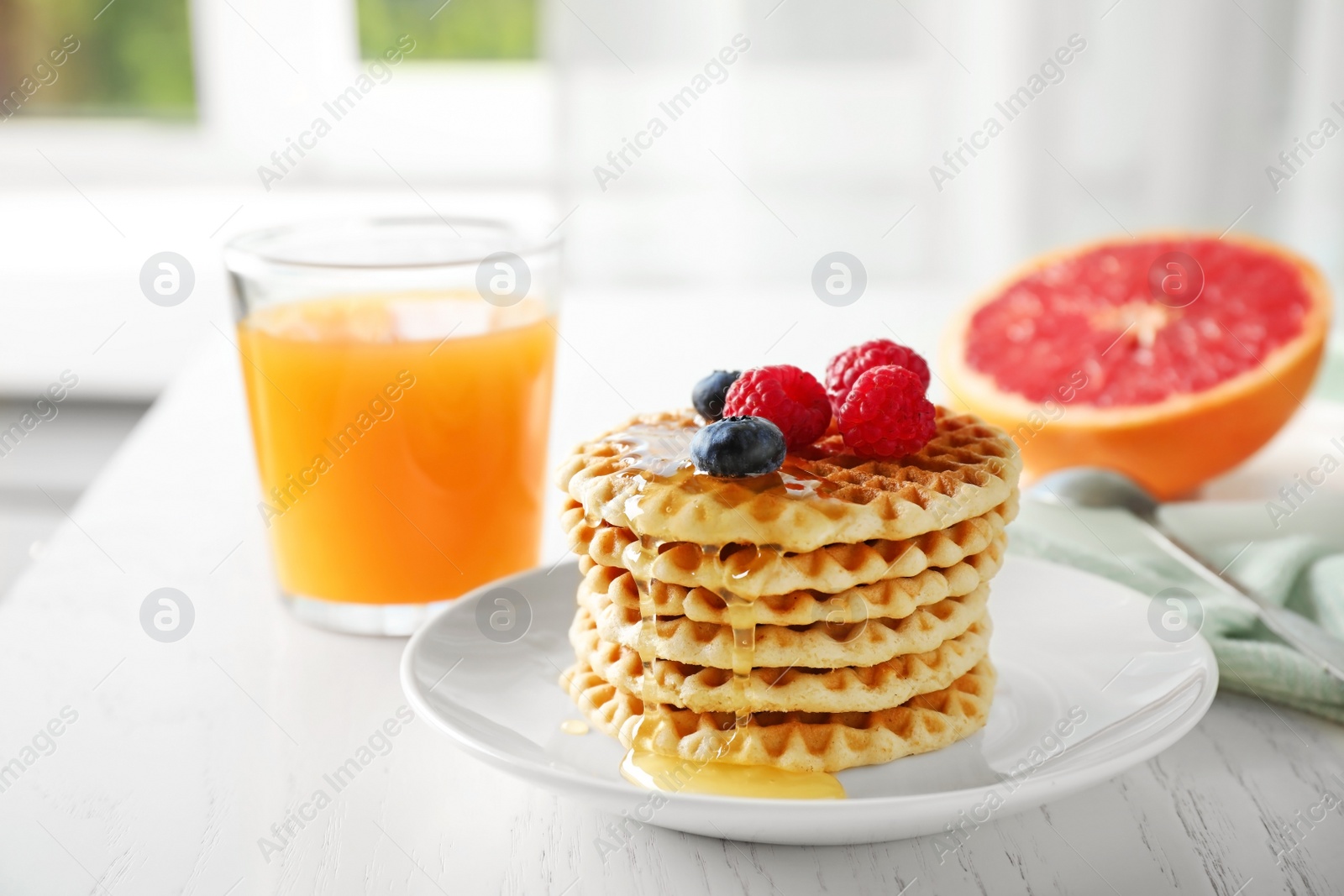 Photo of Tasty breakfast with wafers served on white wooden table